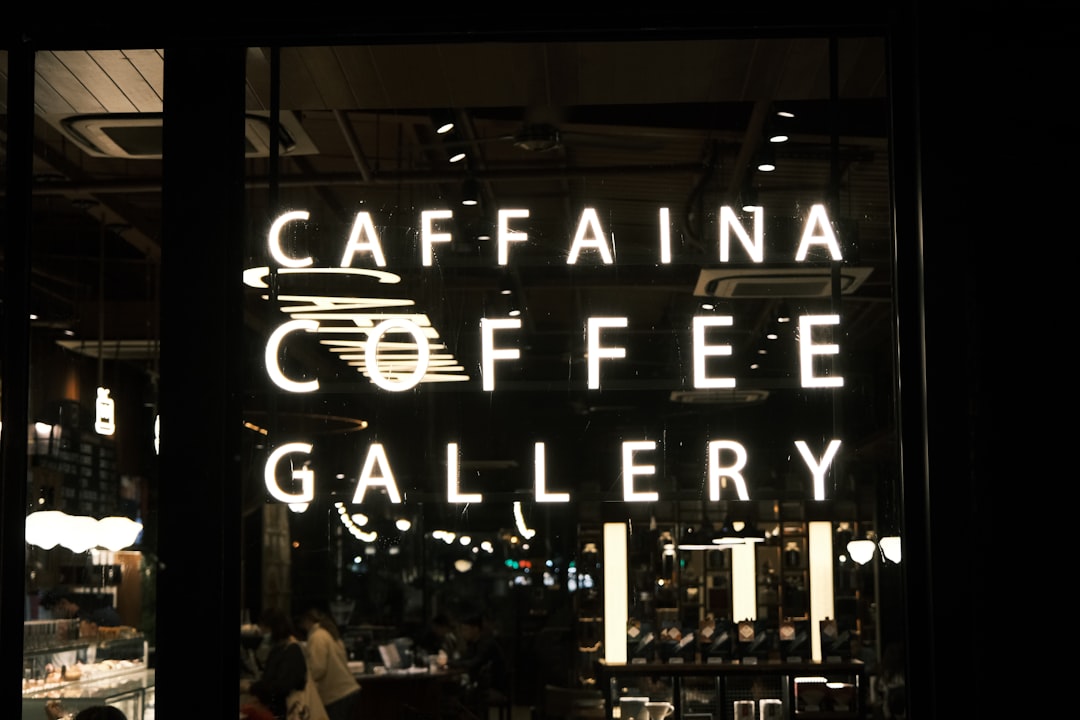 a coffee shop with a neon sign in the window
